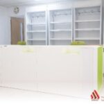 Custom pharmacy shelving system with modular shelves and hygienic finishes, designed for organised medical and retail display