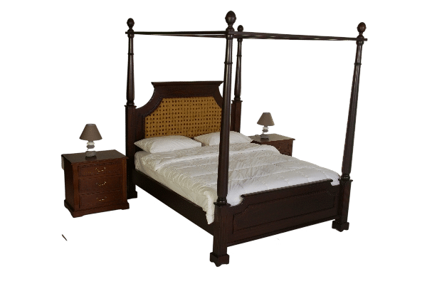 Classic wooden four-poster bed with dark polished wood frame and handwoven cane headboard, styled with white bedding in a warm, elegant bedroom setting.
