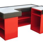 Red L-shaped metal cashier counter with flat work surfaces and open shelves on both sides.